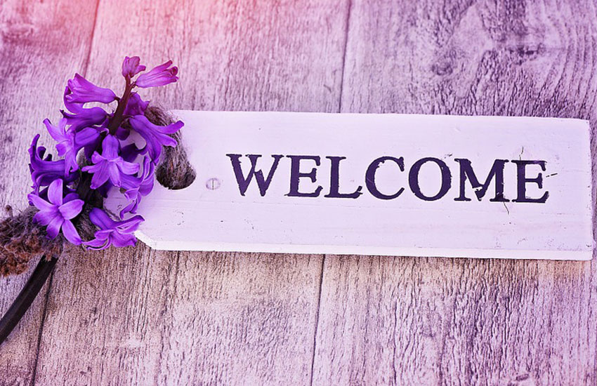 welcome sign with purple flowers