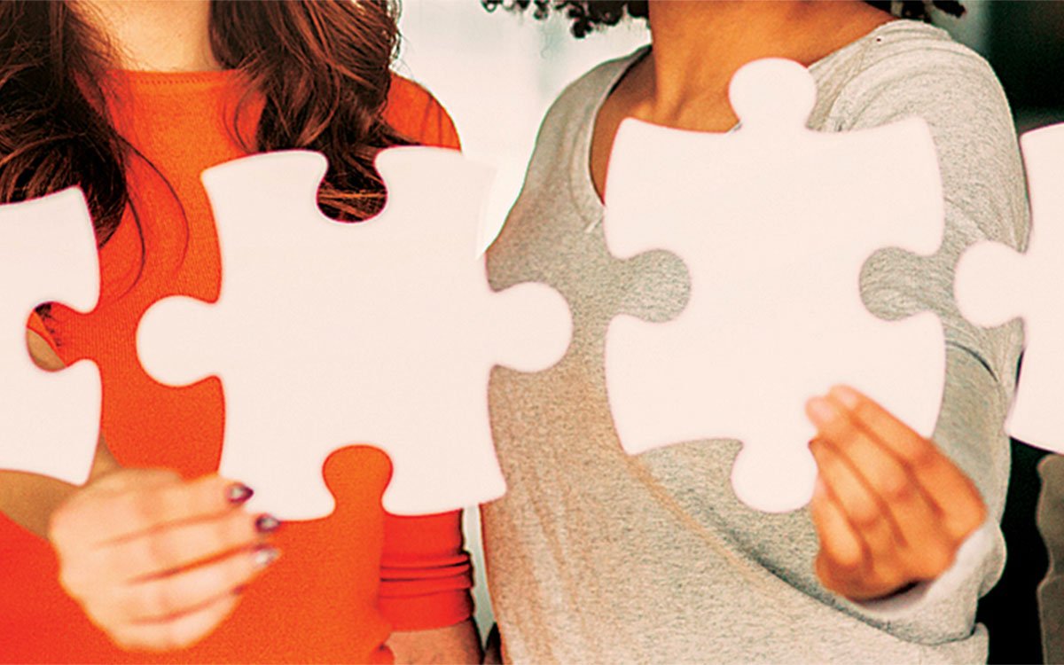 group of people holding large puzzle pieces