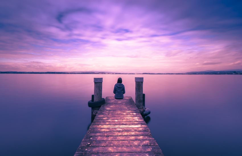 person sitting at end of dock